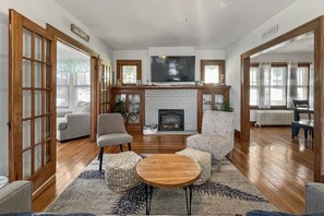 A spacious living room with a fireplace, comfortable seating, and a television.