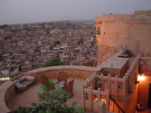 A rooftop terrace with a view of a densely packed cityscape. - Hotel Killa Bhawan (Jaisalmer)