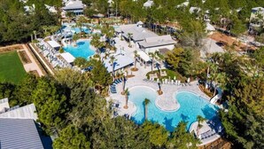 An aerial view of a resort with multiple swimming pools, a large central pool, and a variety of resort buildings surrounded by dense greenery. - WaterColor Retreat with Beach Club Access, Golf Cart, and Private Pool for the Ultimate Escape! (Seagrove Beach)