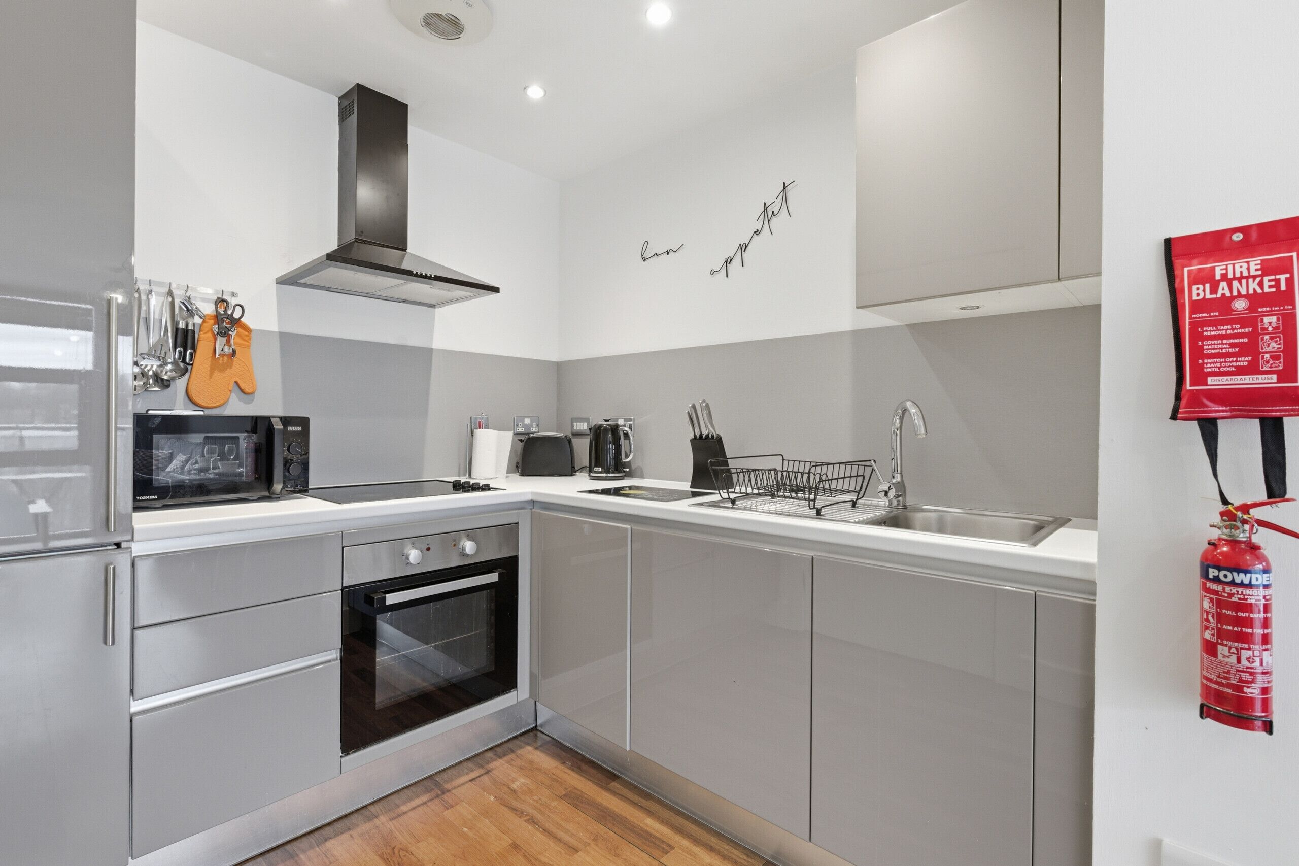 A modern kitchen with stainless steel appliances, a built-in oven, a microwave, and a gas stove.