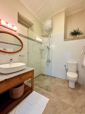 Une salle de bain moderne avec un lavabo sur pied, une douche à parois de verre et des toilettes.