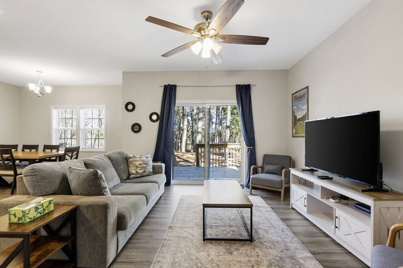 Bright and inviting living space with cozy seating, a large TV, and natural light—perfect for relaxation!