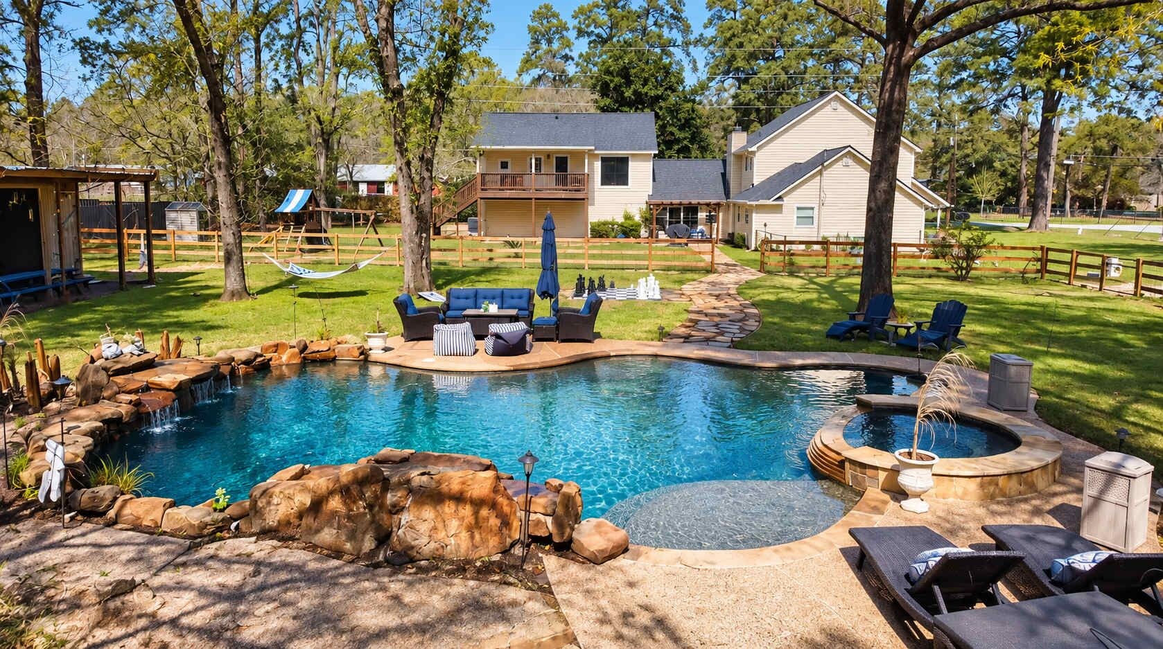 Un patio trasero con piscina, mobiliario exterior y una casa.