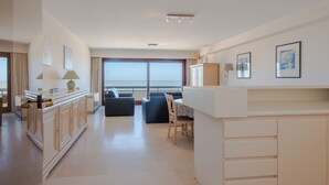 Ein modernes Hotelzimmer mit großem Fenster, Essbereich und einer Küchenzeile.