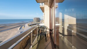 Ein Balkon mit Blick auf Strand und Meer.