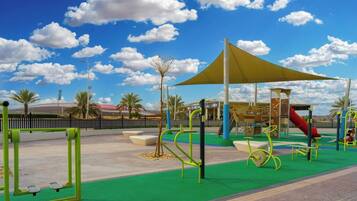 Kids can play on the slide, climbing frames, and swings in this outdoor playground.
