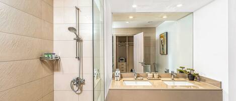 Une salle de bain moderne avec une douche à parois de verre, un meuble-lavabo à deux vasques et un grand miroir.