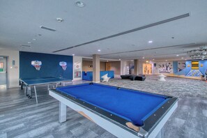 A pool table, a ping pong table, and a climbing wall in a recreational area. - Desert Key - Perfectly Located Yas Island Premier Apts (Abu Dhabi)