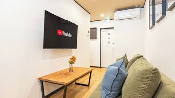 Comfort House | Living area | 50-inch flat-screen TV with cable channels