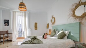 A bedroom with a bed, a wooden chair, a small table, and a window with curtains. - Hotelet Ca'n Oms Mozart by Rentallorca (Petra)