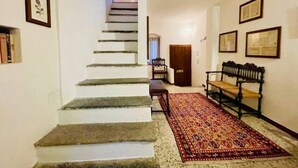 A staircase leading to a landing with a patterned rug and a bench. - Hidden gem Al Lago, authentic yet modern 2-bedroom house in medieval hamlet (Colonno)