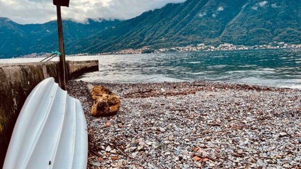 A rocky beach with a white boat and a wooden sign, overlooking a mountainous coastline. - Hidden gem Al Lago, authentic yet modern 2-bedroom house in medieval hamlet (Colonno)