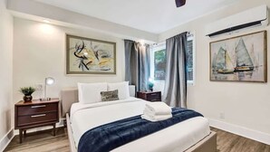 A neatly arranged bedroom with a bed, bedside tables, and artwork on the walls. - Eden Studio Suite Walk to FLT Beach (Fort Lauderdale)