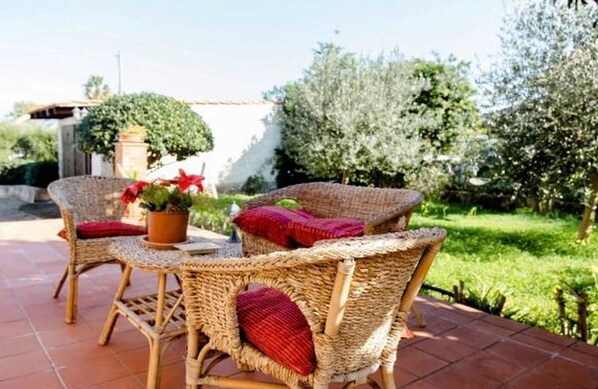 Wicker furniture with red cushions, a potted plant, and a patio setting. - villa in full relaxation near the sea - air conditioning - wifi (Augusta)