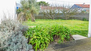 Un jardín con diferentes plantas y una terraza de madera.