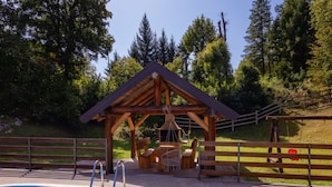 A wooden poolside area with a pool, a wooden gazebo, and a wooden fence. - Holiday Home Elizabeta (Slunj)