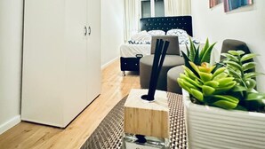 A bedroom with a wooden ceiling, a bed, a nightstand, a potted plant, and a bottle of Calma sandal + amber perfume. - 5BR Apartment Near Kaufpark Alterlaa (Vienna)