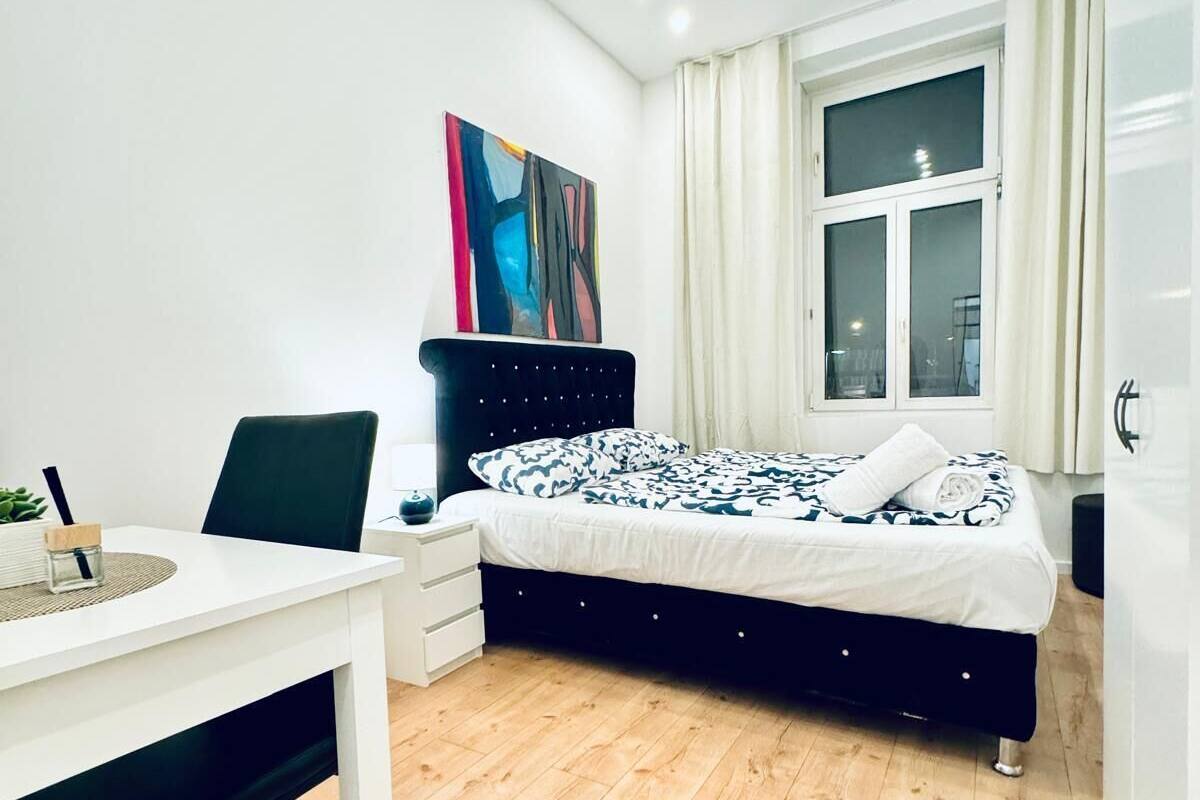 Une chambre à coucher moderne avec un lit, un bureau et une chaise.
