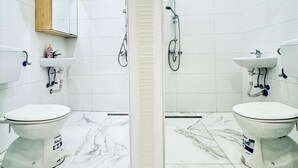 A modern bathroom with two toilets, a shower, and a sink. - 5BR Apartment Near Kaufpark Alterlaa (Vienna)
