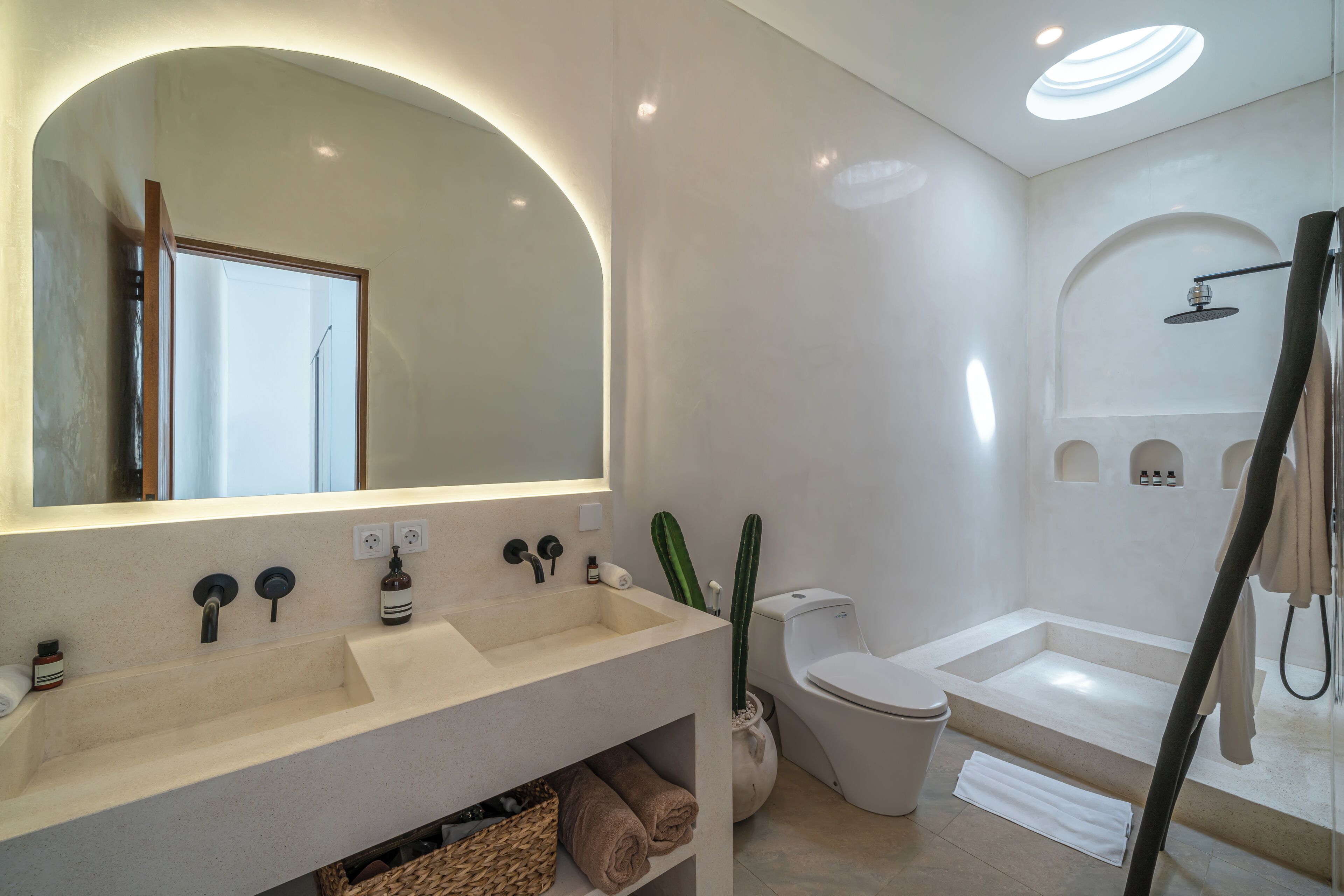 Ein modernes Badezimmer mit großem Spiegel, zwei Waschbecken, Toilette und Badewanne.