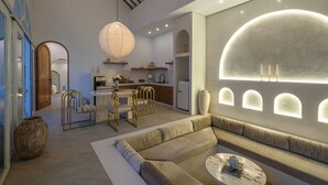 A modern living room with a sofa, a dining area, and a kitchen. - Villa Halle (Cemagi)