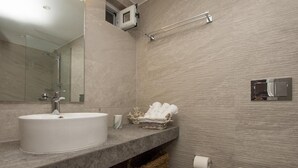 A modern bathroom with a large sink, a mirror, a towel rack, and a toilet. - Sea n City  (Zakynthos)