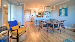 A modern kitchen with a dining area, wooden flooring, and a large island.