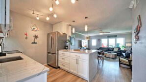 A modern kitchen with a large island, built-in appliances, and pendant lighting.