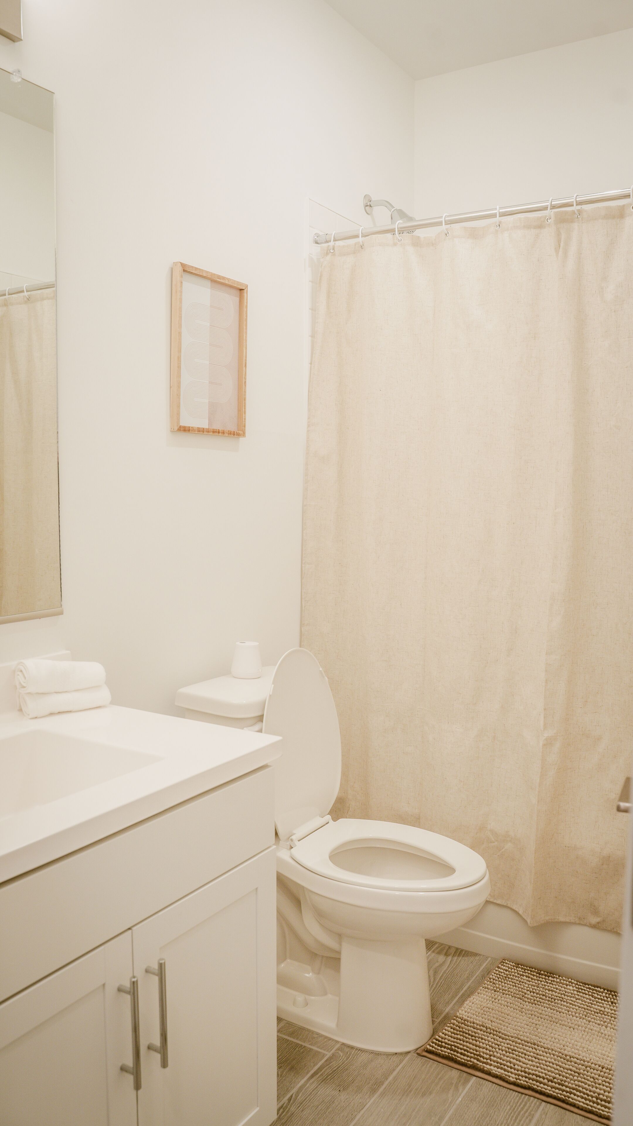 A bathroom with a toilet, sink, and shower curtain.