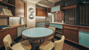 A compact kitchen with a round table and four chairs, wooden cabinets, and a tiled backsplash. - illi Amu Shimokitazawa (Tokyo)