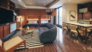 A modern hotel room with a large bed, a sofa, a dining table, and a TV. - illi Amu Shimokitazawa (Tokyo)