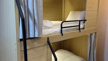 A bunk bed with a wooden frame and a single bed on the top bunk.