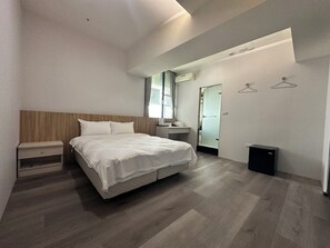 A modern bedroom with a bed, bedside table, and a small desk with a chair. - Star Yi Hotel (Chiayi City)