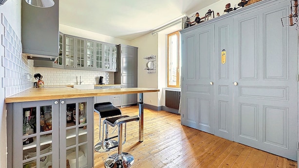 A modern kitchen with a wooden countertop, stainless steel appliances, and a built-in wine rack. - Villa Denise (Vals-les-Bains)