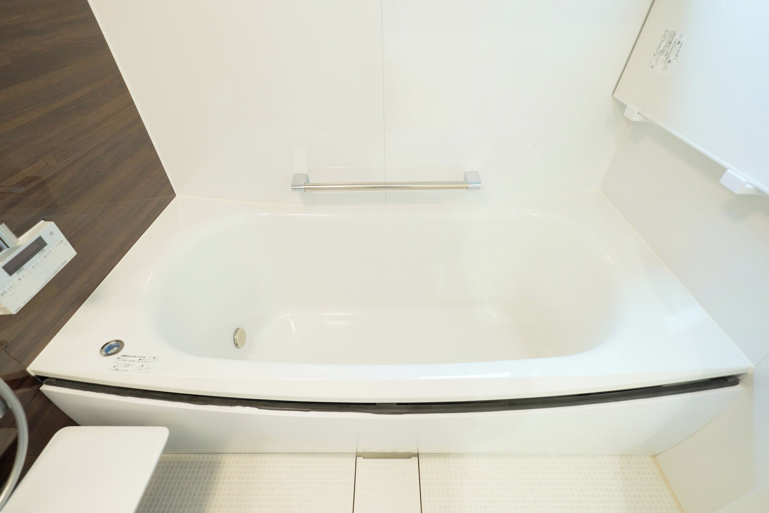 A modern bathroom with a freestanding bathtub, a white toilet, and a tiled floor.
