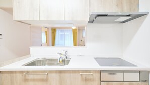 Una cocina moderna con un lavamanos de acero inoxidable, horno empotrado y armarios de madera.