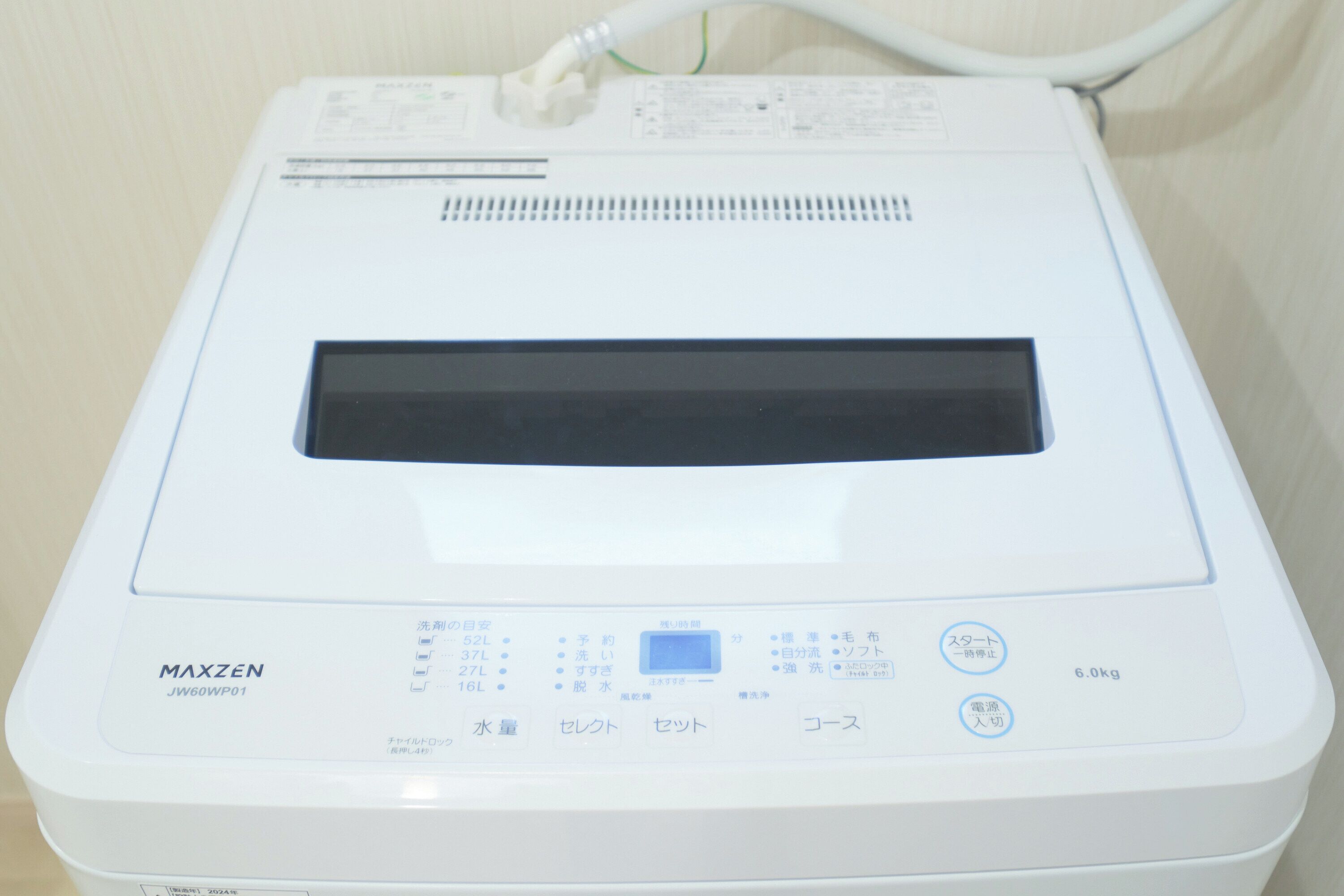 A white medical device with a digital display, buttons, and a label reading "MAXZEN JW60WP01".