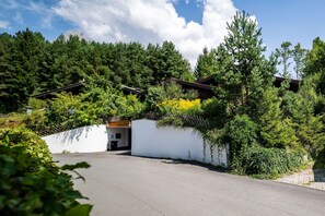 Ein abgelegenes Blockhaus, umgeben von dichtem Wald, mit einer weißen Außenwand und einem Holzdach.