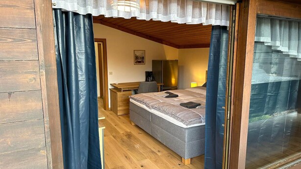 A bedroom with a bed, desk, chair, and a window with curtains. - Alpine Hideaway in Saalfelden (Saalfelden am Steinernen Meer)