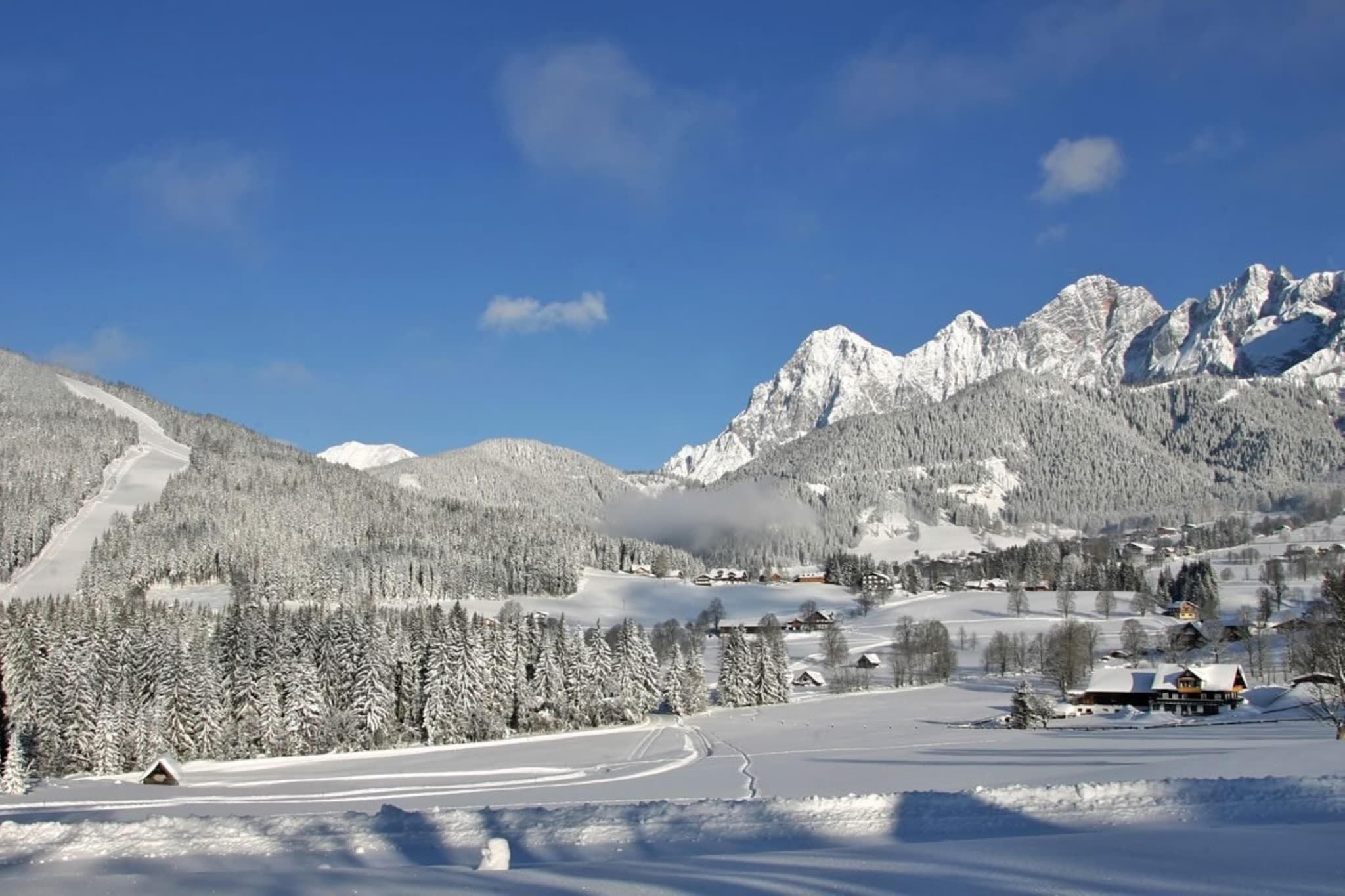 Eine verschneite Berglandschaft mit blauem Himmel.