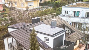 A modern multi-story building with a flat roof, solar panels, a staircase, and a small trampoline in the yard. - Apartment 'Obergeschoss' with Lake View, Balcony and Wi-Fi (Konstanz)