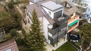 A multi-story building with solar panels, a balcony, and a small garden area. - Apartment 'Exklusive "DG"' with Lake View, Balcony and Wi-Fi (Konstanz)