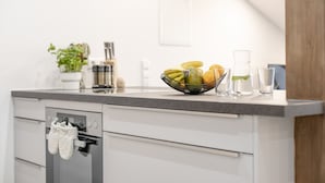 A modern kitchen with a countertop, a bowl of fruit, a glass, and a plant. - Apartment 'Exklusive "DG"' with Lake View, Balcony and Wi-Fi (Konstanz)