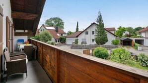 A balcony with wicker furniture, a view of neighboring houses, and a clear sky. - Apartment 'Village Idyll' with Balcony and Wi-Fi in the Picturesque Countryside of Jesenwang (Jesenwang)