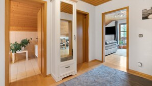 A room with wooden ceiling beams, a white wardrobe, a bench, and a potted plant. - Apartment 'Village Idyll' with Balcony and Wi-Fi in the Picturesque Countryside of Jesenwang (Jesenwang)