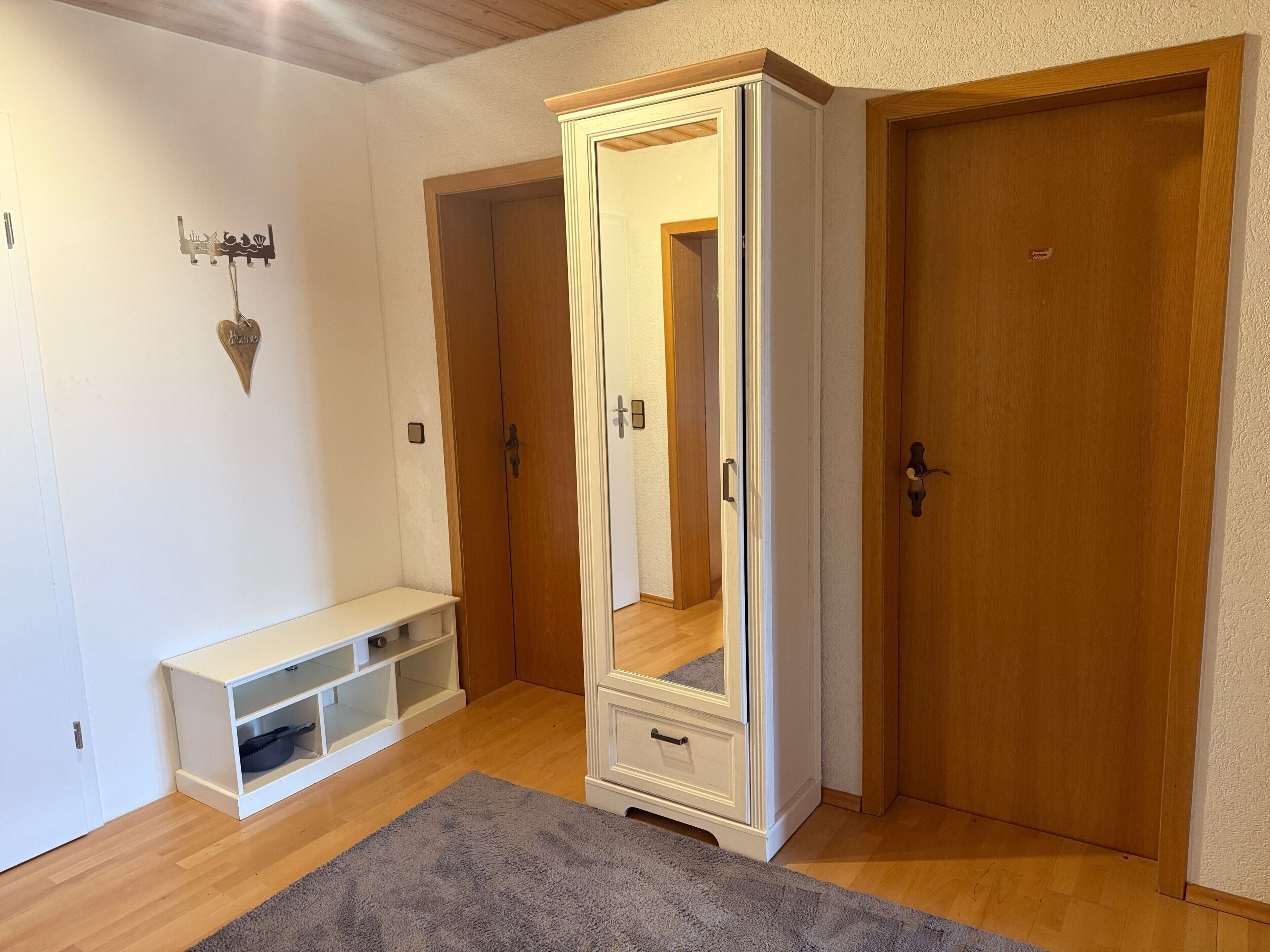 Une pièce comprenant un placard, un banc et un miroir.