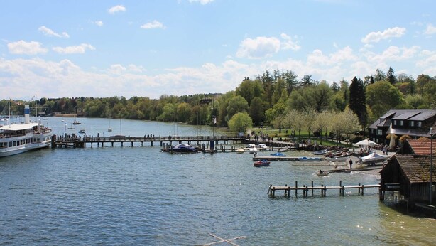 A lake with a dock, boats, and a building with a sloped roof. - Apartment 'Village Idyll' with Balcony and Wi-Fi in the Picturesque Countryside of Jesenwang (Jesenwang)