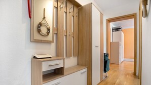 A room with a wooden wardrobe, a mirror, and a desk with a printer. - Apartment 'Meer-Natur-Idyll' with Wi-Fi (Peenemünde)