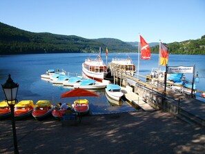 A lakeside dock with boats, a pier, and flags. - Room 'Doppelzimmer 1' with Balcony and Wi-Fi (Titisee-Neustadt)