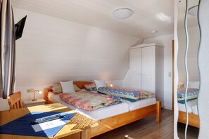 Une chambre à coucher avec un lit en bois, un bureau, une chaise, une armoire et un luminaire au plafond.